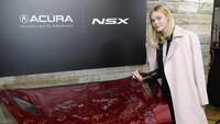 Ia pun tampak memberikan tanda tangannya di atas bagian sebuah mobil. Neilson Barnard/Getty Images for Acura/detikFoto.