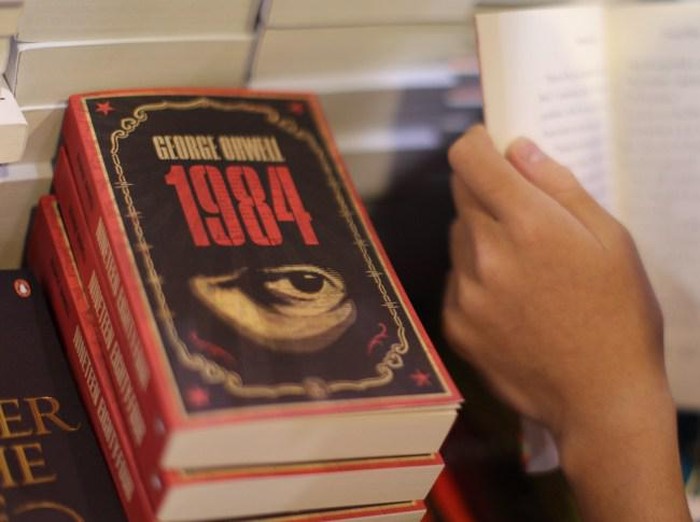 A boy reads a book next to copies of British writer George Orwells 1984 at Hong Kongs annual book fair on July 15, 2015. The 26th edition of the fair showcased a record number of over 580 exhibitors from 33 countries and regions. AFP PHOTO / Aaron Tam        (Photo credit should read aaron tam/AFP/Getty Images)