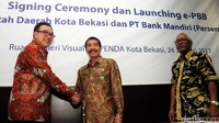 Regional Retail Banking Head Bank Mandiri Ratmoko Hadi berjabat tangan dengan Kepala Dinas Pendapatan Daerah Pemerintah Kota Bekasi Aan Suhanda usai penandatanganan kerja sama, Kamis (26/1/2017).
