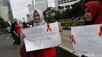 Peserta sosialisasi HIV/AIDS memegang poster tentang pertanyaan dan mitos seputar penyakit tersebut.