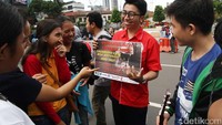 Warga yang tengah menikmati CFD melihat poster terkait HIV/Aids.