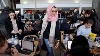 Seorang pengacara bernama Noor Zafar, terlihat sibuk membantu sejumlah imigran yang tertahan di Bandara Internasional John F. Kennedy, Queens, New York, karena larangan perjalanan atas kebijakan Trump. REUTERS/Andrew Kelly.