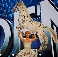 Peserta asal Swedia, Ida Ovmar, mengangkat kuda dengan tangannya di Miss Universe 2016. Kostumnya juga tak kalah unik, ia mengenakan gaun potongan mullet yang dihiasi foto di sepanjang roknya. Di dalamnya, Ida memakai kaus kaki berbeda untuk kesan quirky. Foto: Reuters