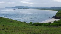 Foto: Saat ini pun Bukit Merese sedang hijau-hijaunya di musim penghujan. Rerumputan yang hijau berpadu warna langit biru dan lautan di bawahnya begitu memanjakan mata (Kurnia/detikTravel)