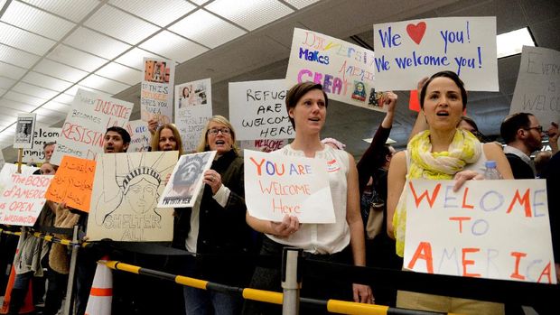 Demonstran menyambut imigran di Bandara Internasional Dulles