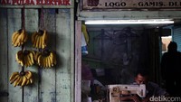 Penjahit membordir pakaian di kiosnya.