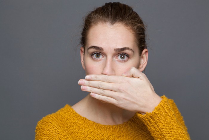 beautiful young woman checking her breath
