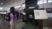Pengunjung melihat salah satu koleksi mesin pencetak uang.