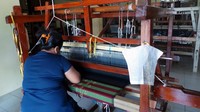 Foto: Setiap pekerja memiliki contekan pola motif kain yang harus ditenun pada selembar kertas yang ditempelkan pada alat tenun mereka. Kurang lebih ada 7 orang yang bekerja untuk workshop tenun Wan Fitri (Wahyu/detikTravel)