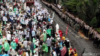 Massa pro Habib Rizieq Syihab merapikan kembali alas yang digunakan untuk salat. Mereka kemudian melanjutkan aksi dengan orasi dan pembacaan ayat-ayat suci.