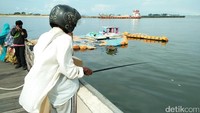 Bukan cuma sebagai tempat santai, Pantai Losari juga jadi tempat mancing warga lokal. Mereka akan berdiri di pinggir dermaga sambil menunggu ikan yang tersangkut di kail (Bonauli/detikTravel)