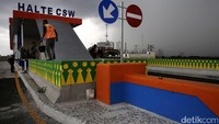 Pekerja menyelesaikan pengecatan halte.