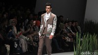 Model beraksi memamerkan busana karya Ariy Arka.