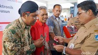 Plt Gubernur DKI Jakarta Soni Sumarsono menyerahkan Kartu Jakarta One kepada penghuni Rusun Pesakih. Pool/Bank DKI.