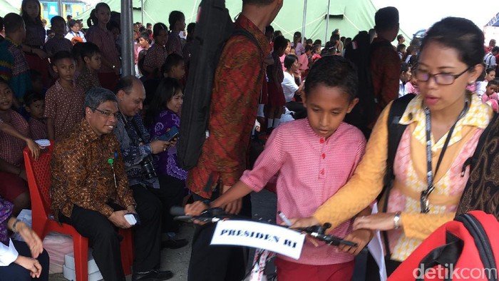 Tiba di Ambon, Jokowi Langsung Bagi-bagi Biskuit dan Kartu Sakti