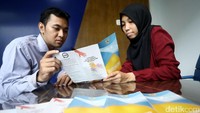 Dua orang petugas membaca pamflet di ruang pusat pelayanan laporan masyarakat yang baru saja diresmikan Ombudsman.