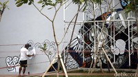 Pekerja tengah mengerjakan grafiti tersebut.