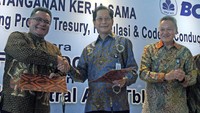 Presiden Direktur PT Bank Central Asia Tbk (BCA) Jahja Setiaatmadja (tengah) bertukar nota kesepahaman (MoU) dengan Ketua Umum The Financial Markets Association of Indonesia (ACI FMA) Branco Windoe (kiri) disaksikan Direktur BCA Rudy Susanto (kanan). Pool/dok. BCA.