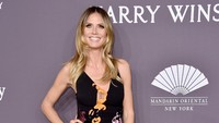 Dengan dress hitam, Heidi Klum tampil menawan sekaligus seksi. Michael Loccisano/Getty Images