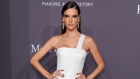 Alessandra Ambrosio memilih gaun putih dengan belahan tinggi yang memamerkan kaki jenjangnya. Craig Barritt/Getty Images for FIJI Water