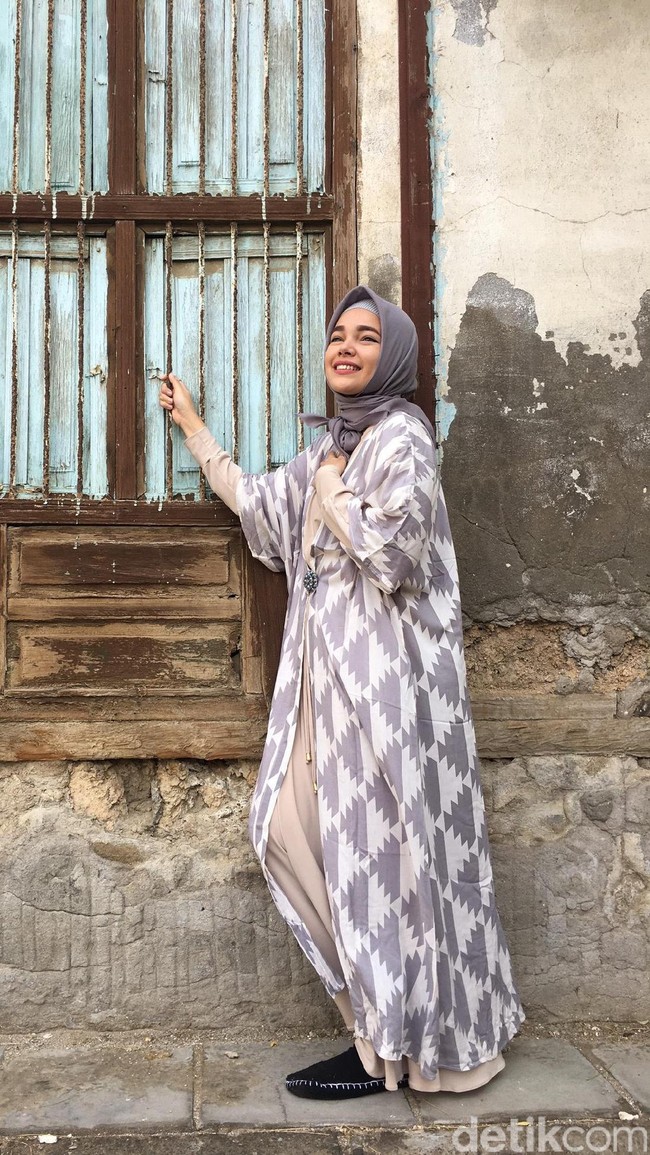 Outerwear panjang bermotif bisa menyemarakkan penampilan Anda saat sholat Ied pakai maxi dress polos. Coba lihat gaya Dewi Sandra ini yang stylish dan simpel.  Foto: Arina Yulistara/Wolipop