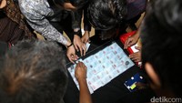 Petugas mengecek KTP palsu yang dikirm dari Kamboja.