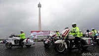 Polisi dengan motor besar melintas di depan Monas.