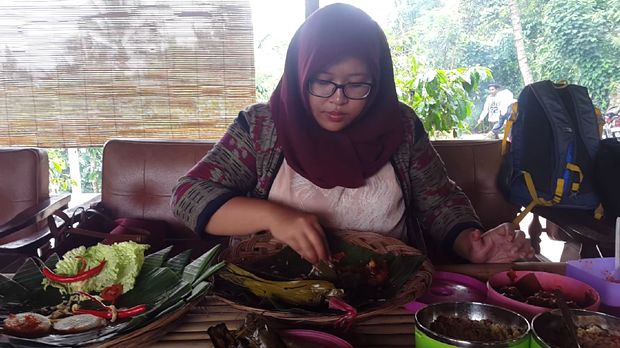  Farah asyik mencoba kuliner nasi lemeng (Putri Akmal/detikTravel)