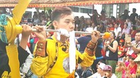 Tatung muda berkostum barongsai ini juga ekstrem. Pipinya ditembus besi besar dan ujungnya adalah baling-baling yang bisa berputar. Bukan main! (Fitraya/detikTravel)