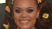 Andra Day dengan gaya rambut keriting ditambah aksen bunga yang memberikan tampilan anggun dan tampil feminim. Alberto E. Rodriguez/Getty Images for NARAS
