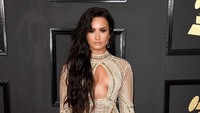 Demi Lovato tampak seksi dengan busana transparan berwarna emas rancangan Julien Macdonald. Frazer Harrison/Getty Images