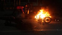Petugas memeriksa kondisi korban di depan sepeda motor yang terbakar akibat ledakan. Seperti diketahui, ledakan itu terjadi dalam sebuah aksi protes yang sedang digelar oleh para ahli kimia dan produsen farmasi Pakistan. Sedikitnya 10 orang telah tewas akibat ledakan itu. Mohsin Raza/Reuters/detikFoto.