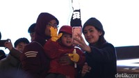 Tak hanya orang dewasa yang melawan dingin, tampak anak-anak ikut larut bersama orang tuanya. Mereka tampak asyik berfoto di Jembatan Ebisubashi dengan latar belakang papan neon Glico, salah satu papan reklame ikonik Dotonburi (Andi/detikTravel)