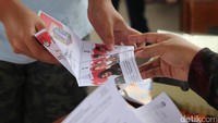 Warga mengambil surat suara Pilgub DKI.