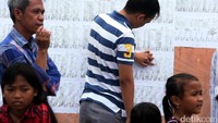 Warga mengecek daftar pemiluh tetap.