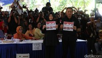 Agus dan Annisa menunjukkan surat suara sebelum mencoblos.