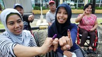Para disabilitas tersenyum sambil memperlihatkan jarinya setelah menggunakan hak pilihnya pada Pilkada DKI Jakarta 2017.