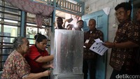 Warga dibantu petugas mencoblos.