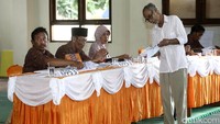 Seorang warga mengambil surat suara ke petugas KPPS.