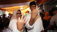 Anies Baswedan dan Fery Farhati Ganis menunjukkan tiga jarinya yang telah dicelupkan ke tinta.