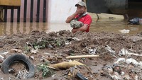Seorang warga melintas di jalanan yang terendam banjir.