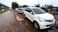 Warga terpaksa memarkir kendaraannya di pinggir jalan karena rumahnya terendam banjir.