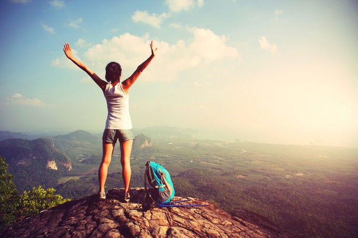 woman hiker enjoy the view at landscape on mountain peak cliff