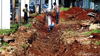 Sejumlah pekerja membuat saluran air di Jalan Asia Afrika, Senayan, Jakarta Selatan, Jumat (17/2).