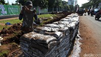 Tanah-tanah yang basah dan berupa lumpur dimasukan ke dalam karung sebelum diangkut dan dibuang.