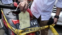 Polisi memasang garis polisi pada sepeda motor yang diduga hasil kejahatan.