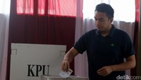 Seorang warga tengah memasukan surat suara ke dalam kotak usai pencoblosan.