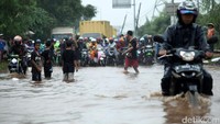 Beberapa pengendara sepeda motor nekat menerobos genangan.