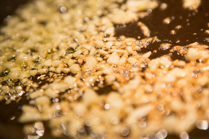 sauteing garlic in a pan with olive oil