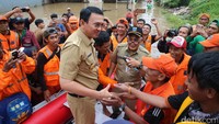 Ahok menyalami Pasukan Oranye dari atas perahu karet.